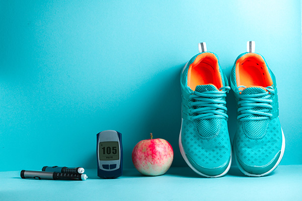 A diabtetes monitor, an apple and a pair of trainers